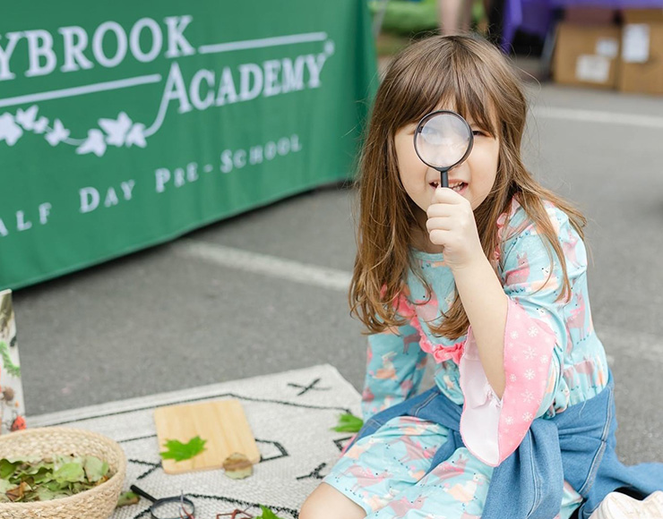 little girl looking through a magnifying glass